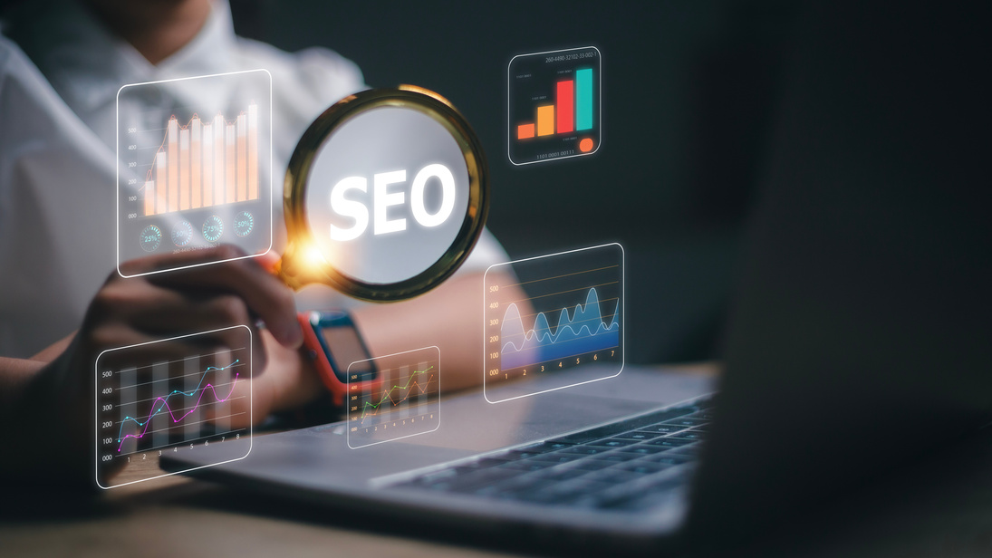 SEO magnifying glass with data charts on a laptop screen, emphasizing Prime Virtual Solutions’ SEO and web design services that boost online visibility for realtors and loan officers in Las Vegas, NV.