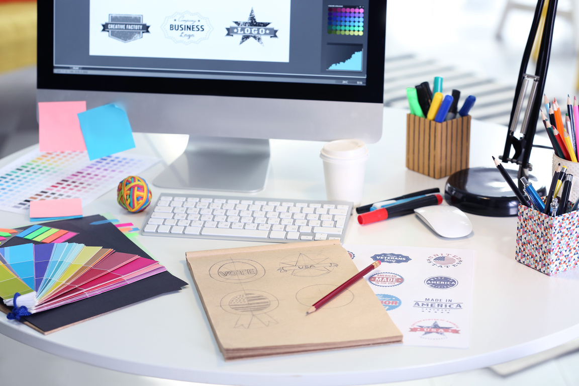 A creative workspace with logo designs and sketches, highlighting Prime Virtual Solutions’ graphic and logo design services for professional branding of realtors and loan officers in Las Vegas, NV.